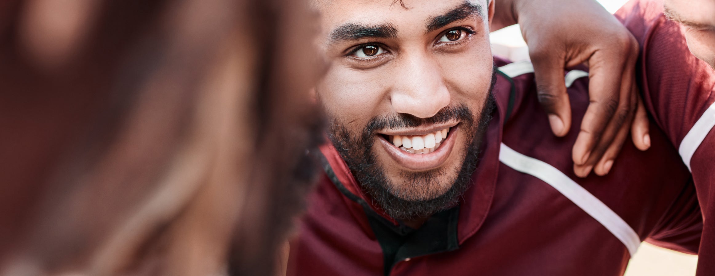  a man smiling surrounded by other men